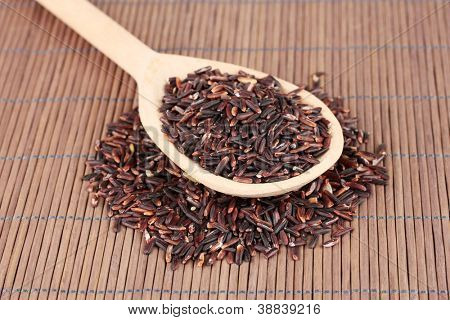 arroz preto com colher de pau, na esteira de bambu