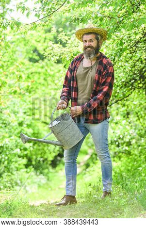 Summer Farm. Agriculture And Tough Work Concept. Gardening Or Planting Concept. Man Using A Big Wate