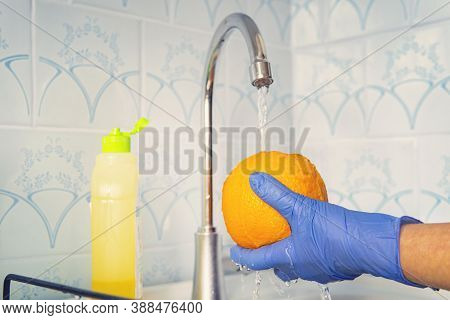 Person Washes Fruit With Eco Soap For Washing In A Kitchen With Blue Walls. Decontamination And Disi