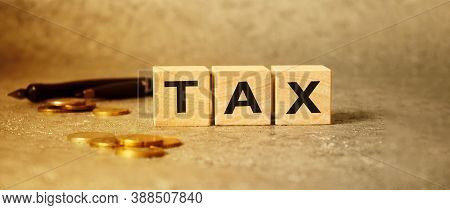 The Inscription Tax On The Texture Of Wooden Cubes On The Background Of Manet. An Inscription On A F