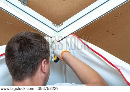 Process Of Installing Stretch Ceiling In The Hall. Close Up Of The Hand Of Man With A Tool