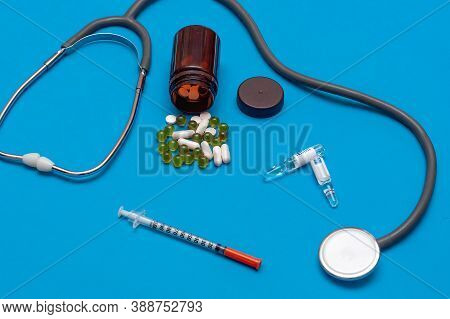 Composition Of Pills, Ampoules, Syringes, Stethoscope On Blue Background. Healthcare Concept. Corona