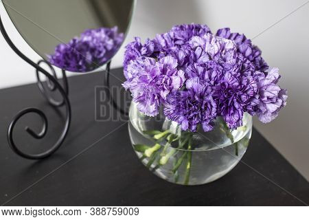 Bridal Bouquet Of Lilac Carnations In A Round Glass Vase As Table Decoration