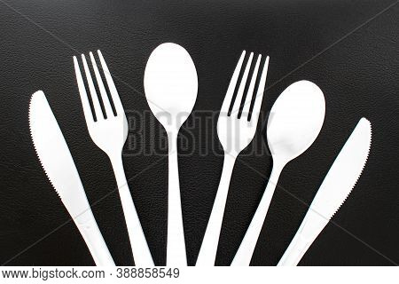 Single Use White Plastic Cutlery On A Leather Background. Concept: Ban Single Use Plastic
