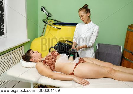 Woman Getting Cryolipolysis Fat Treatment Procedure On Belly In Beauty Salon