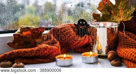 Candles With Sweater And Ghost Pumpkin, Dried Leaves On Windowsill. Halloween Home Decoration. Rainy