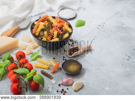 Fusilli Pasta In Black Bowl With Parmesan Cheese And Tomatoes, Oil And Garlic With Basil And Linen T