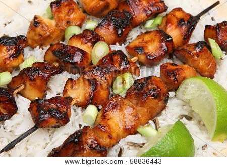 Teriyaki chicken kebabs with rice.