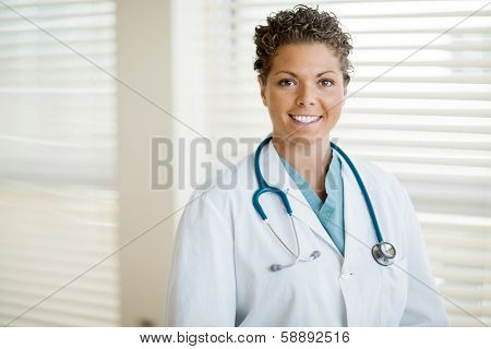 Portrait of happy female cancer specialist in labcoat standing at clinic