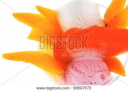 small transparent glass cup with ice cream and tropical fruits isolated on white background