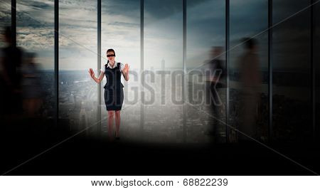 Redhead businesswoman in a blindfold against room with large window looking on city