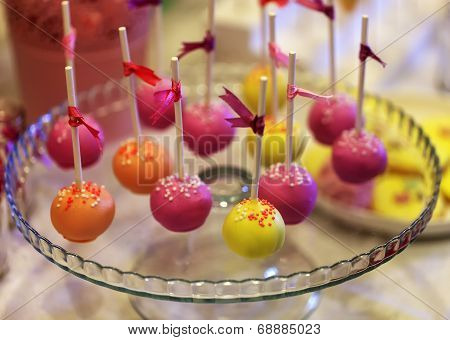 Colorful cake-pops on a glass plate