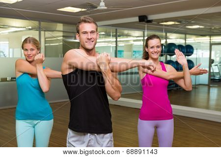 Fitness class led by handsome instructor at the gym