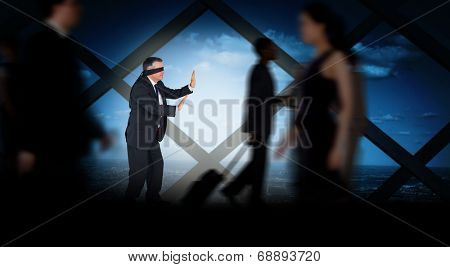 Mature businessman in a blindfold against room with large window looking on city