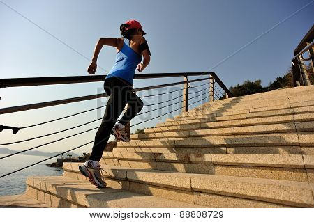 healthy lifestyle sports woman running up on stone stairs sunrise seaside