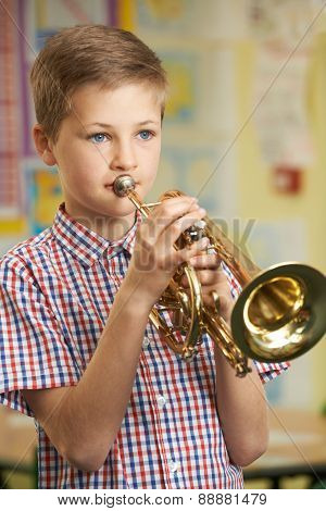 Boy Learning To Play Trumpet In School Music Lesson