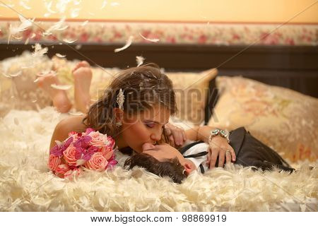 Bride And Groom Playing With Feathers Pillow Fight Bed Wedding Day