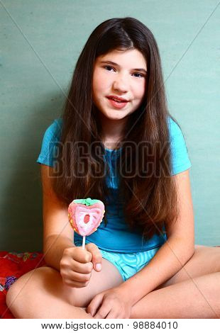 preteen beautiful girl with strawberry candy on stick