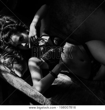 Beautiful lady in sexy lingerie lies on a sofa