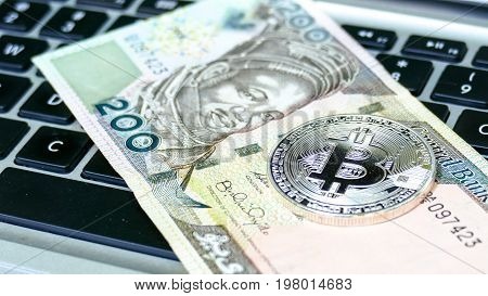Bitcoin on Nigerian Naira banknote. Electronic money exchange concept
