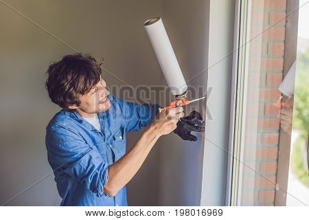 Man In A Blue Shirt Does Window Installation
