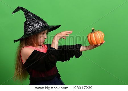 Girl With Carved Orange Pumpkin Isolated On Green Background