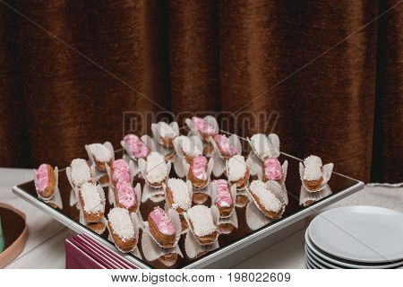 Eclairs traditional french dessert. candybar on a glass table