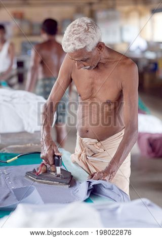 COCHIN, INDIA - JANUARY 21, 2016: Indian man working hard on Dhobi Ghat in Fort Cochin, South India