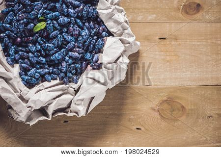 Fresh Honeysuckle Blue Berry Fruits With Leaf On A Wooden Background