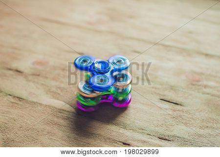 Colored Fidget Spinners Stress Relieving Toy On Wooden Background