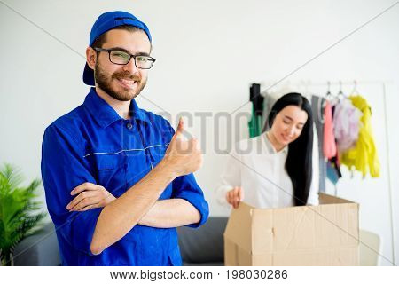 A portrait of a smiling deliveryman showing thumbs up