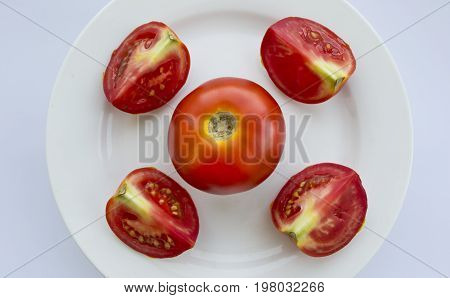 Slices of ripe tomato on a white plate