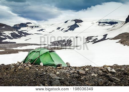 Camping with tent in snowy mountains and glaciers of Iceland. Stormy winds in Porisdalur