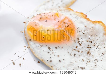 Closeup view of over hard fried egg on white plate