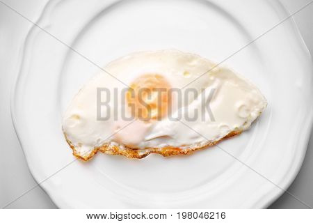 Plate with over hard fried egg on light background