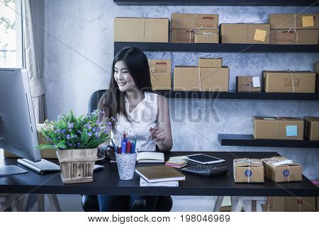 Young asian teenager owner business woman work at home for online shopping writing the order and prepaing package the product with office equipment entrepreneur and alpha generation life style concept