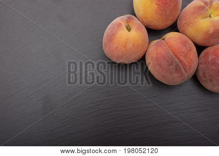 Ripe Peach ion black background of slate or stone.