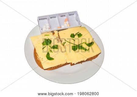 Simple cheese bread with fresh herbs and a medicine box on a white plate against neutral background.