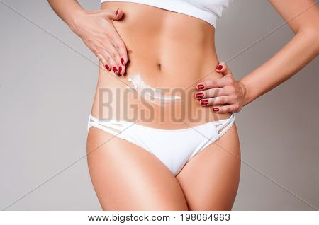 Woman Applying Moisturizer Cream Lotion On Belly.  Woman Wear White Underwear