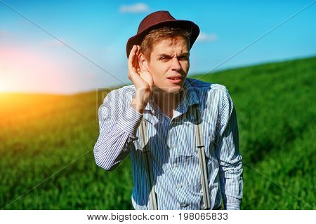 Handsome Man In The Nature Tries To Hear Something With Putting His Hand To His Ears