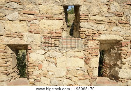 Narrow vertical apertures on historical walls in the medieval city of Girona Catalonia Spain