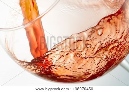 Wine splashing on glass isolated on white background