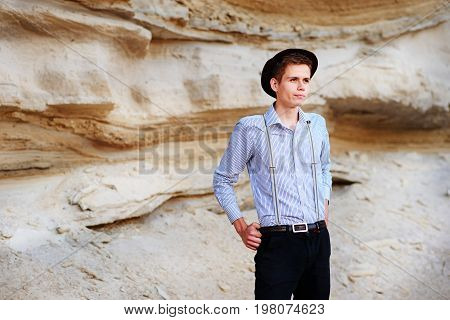 Stylish Attractive Man Stands In The Middle Of A Sand Quarry And Poses On The Camera