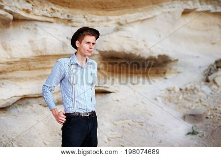 Stylish Attractive Man Stands In The Middle Of A Sand Quarry And Poses On The Camera