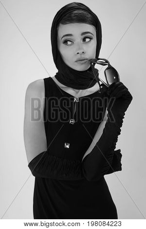 beautiful young woman in retro style with sunglasses and a head scarf black and white photography