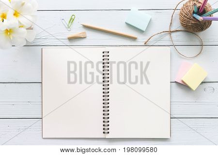 Modern white office desk top wood table with notebook notepad and other supplies. Top view with copy space on white background. Top view flat lay.