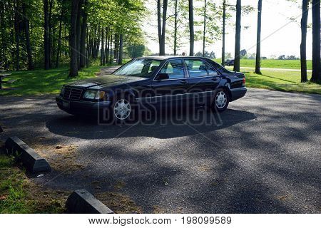 FIFE LAKE, MICHIGAN / UNITED STATES - MAY 27, 2017: A 1996 black Mercedes-Benz S420 luxury sedan is parked in the parking lot of the Michigan Department of Transportation Roadside Park, honoring J. Charles Brown, on U.S. Highway 131.