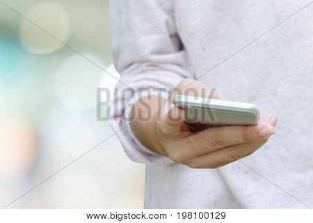 Woman hand using smart phone over blur bokeh background business and technology concept gen Z digital marketing lifestyle the internet of things social media network