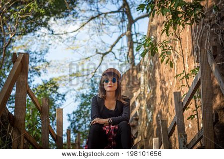 Tourist Young Woman Wearing Hat Enjoying Sitting On The Stairs Mountain.