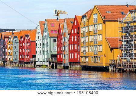 Famous wooden colored houses in Trondheim city Norway. Colorful houses on stilts in sunny day.